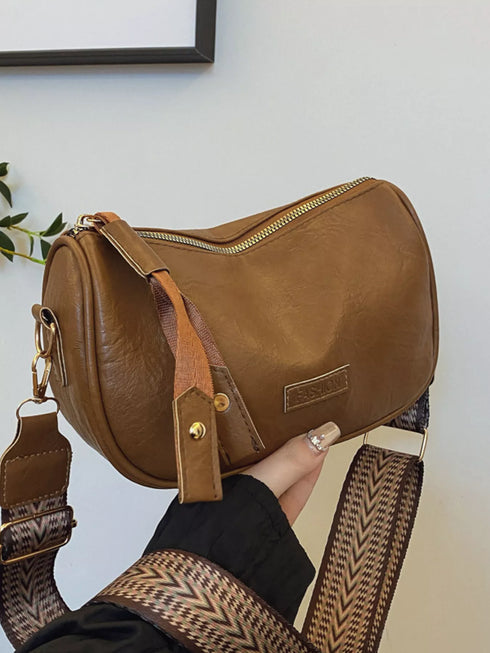 Back view of brown crossbody bag held in a hand