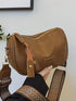 Back view of brown crossbody bag held in a hand