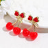 Pair of red cherry earrings with gold-tone stems and bow details