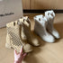 Beige and brown perforated western ankle boots displayed together