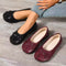 Black bow-detail split-toe flats worn beside a burgundy pair
