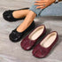 Black bow-detail split-toe flats worn beside a burgundy pair