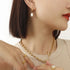 Freshwater pearl hoop earring worn on a model with layered necklaces