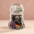 Side view of Halloween mystery jewelry jar showing assorted jewelry and seasonal designs.