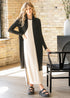 Black open-front cardigan worn over a light dress