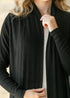 Close-up of black cardigan neckline and rib-knit sleeves