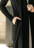 Close-up of a hand in the black cardigan pocket