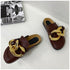 Brown chain mule flats shown together at a three-quarter angle