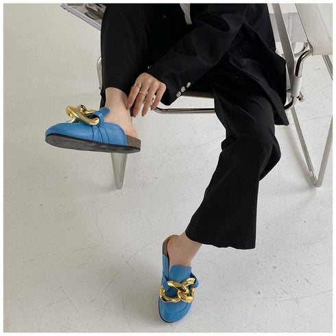 Blue STEVVEX mules worn with black trousers, showing low side profile
