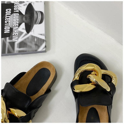 Close-up of black chain mule flats and tan footbeds