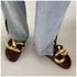 Brown chain mules beneath light blue wide-leg jeans