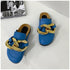 Pair of blue microfiber chain mule flats on white