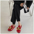 Red chain mule flats worn with wide cropped black trousers