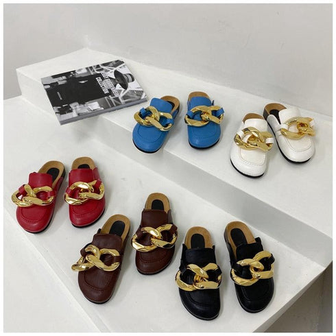 Five colors of STEVVEX gold-tone chain mules grouped on a white table