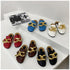 Five colors of STEVVEX gold-tone chain mules grouped on a white table