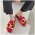 Red closed-toe chain mules worn with cropped black pants