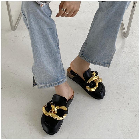 Black chain mules styled with light blue straight-leg jeans