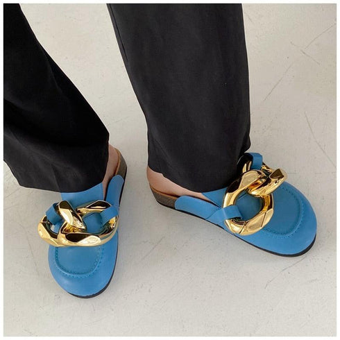 Blue chain-detail mules shown while worn, viewed from above