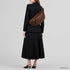 Chocolate Genova crossbody bag shown on a model with tailored clothing