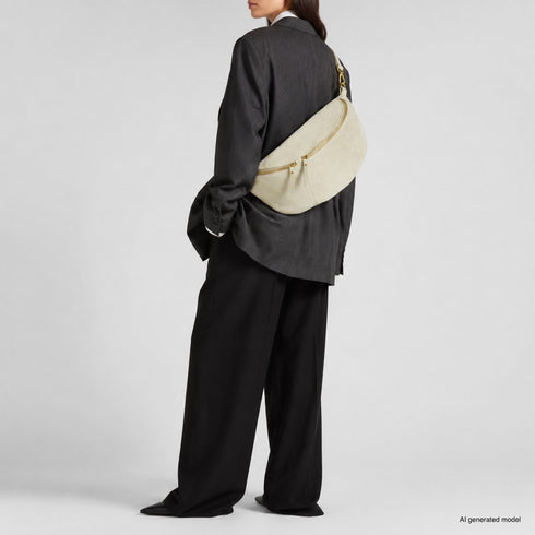 Beige Genova crossbody bag shown on a model with tailored clothing