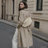 Beige Genova bag styled across the body on a model outdoors