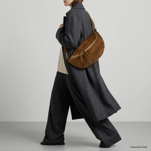 Mocha Genova crossbody bag shown on a model with tailored clothing