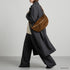 Mocha Genova crossbody bag shown on a model with tailored clothing