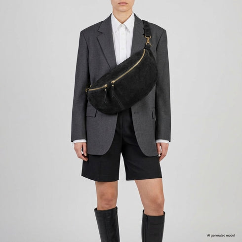 Black Genova crossbody bag shown on a model with tailored clothing