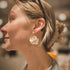 White Florita flower drop earring worn on a small gold-tone hoop