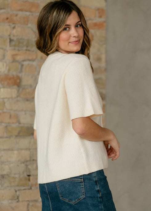 Over-the-shoulder view of the Zadie ivory cardigan showing the back and sleeve shape