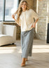 Full-length outfit showing the ivory Zadie cardigan with a dark printed midi skirt
