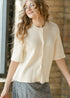 Zadie cream cardigan worn buttoned, showing the rounded neckline and relaxed shape